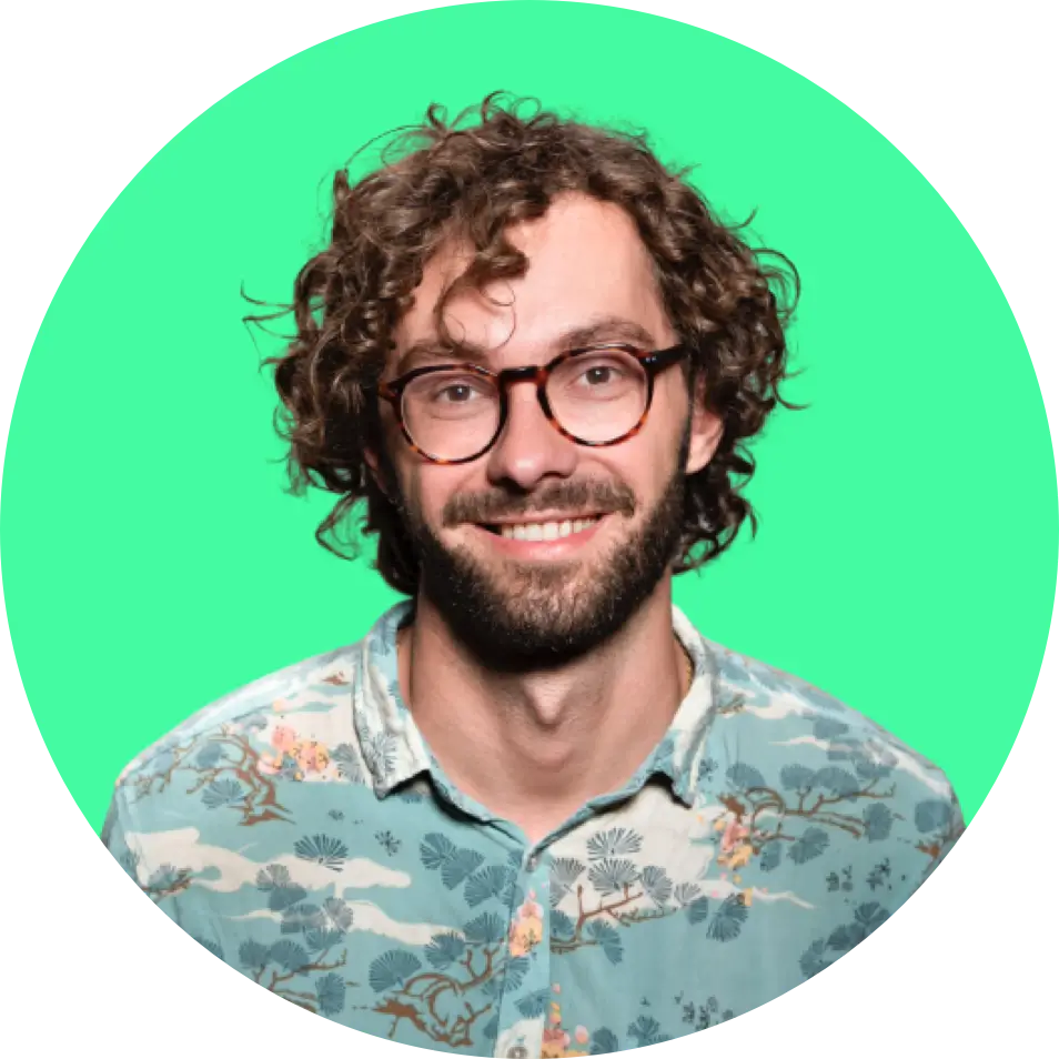 image of the founder: a man with curly brown hair and beard wearing glasses on a green background